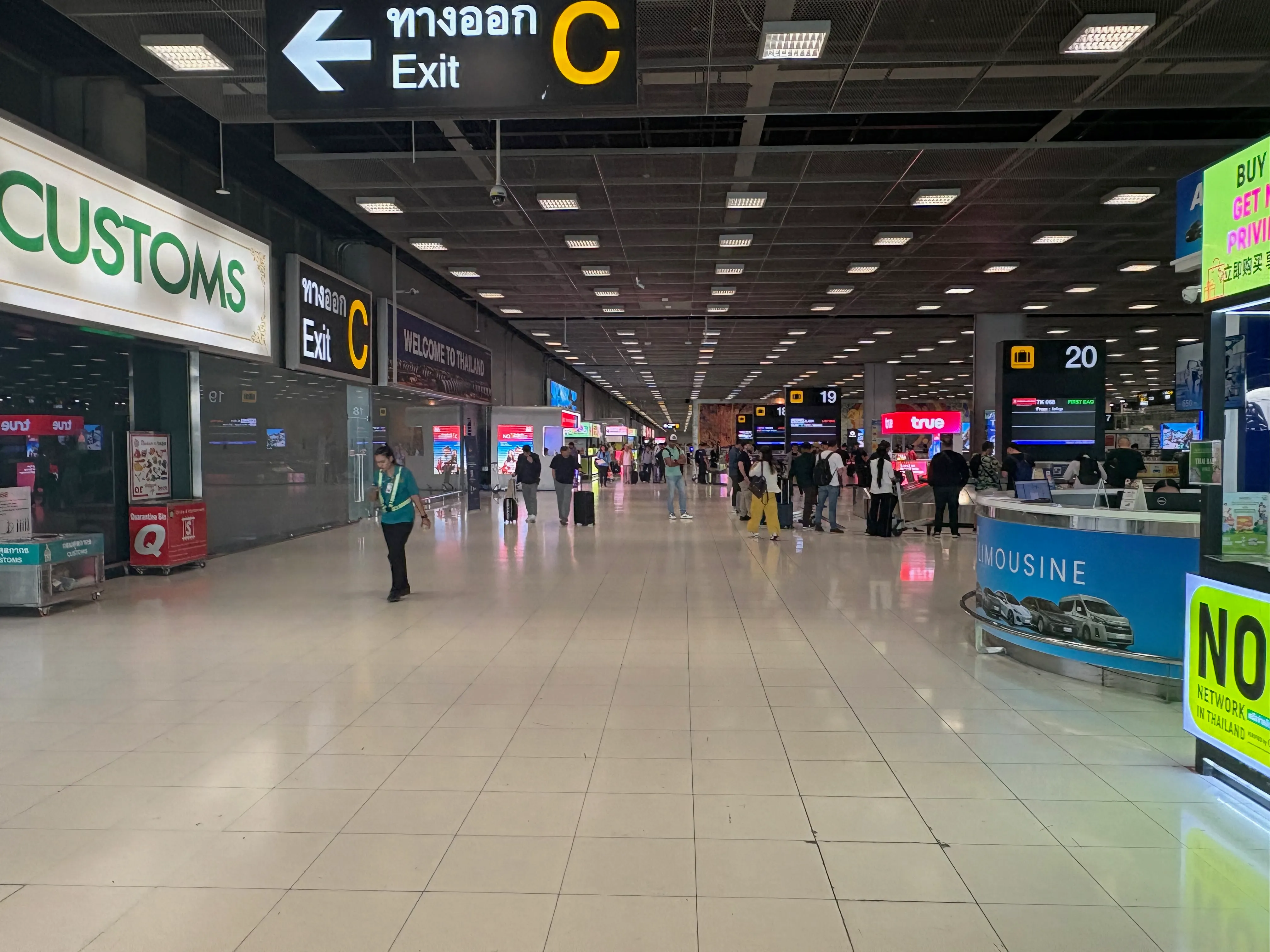 スワンナプーム空港内。「← Exit C」の案内サインと、広がるコンコース。